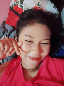 Beautiful young woman smiling and making a heart shape with her fingers