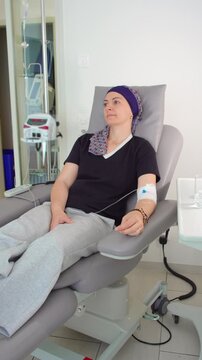 Woman undergoing chemotherapy treatment in oncology center, seated in medical recliner with intravenous infusion, cancer care, recovery and healthcare support
