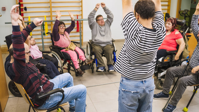 Diverse group of people with disabilities and a physiotherapist engaging in rehabilitation exercises, promoting health and inclusion