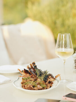 Fire-roasted lamb ribs and a glass of white wine for a sunny summer lunch.