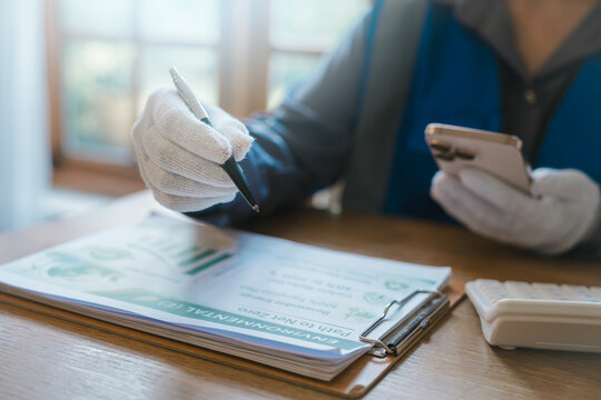 Digital ESG tracking smart sustainability concept industrial worker in white gloves using smartphone and pointing at net zero environmental report