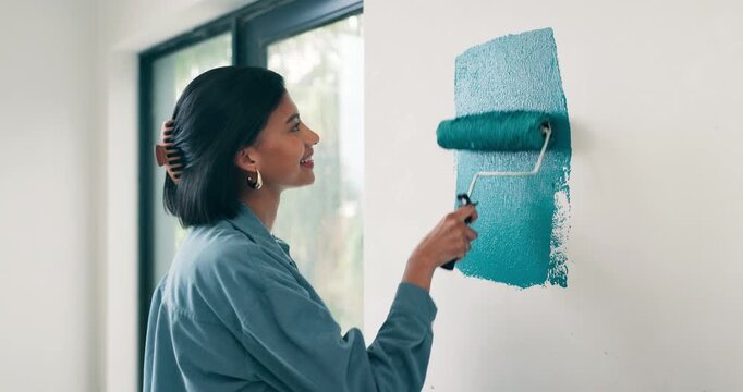 Happy, woman and painting with roller for home renovation, interior design and property upgrade. Creative, person smile and art tools in house with diy project, remodeling process and maintenance.
