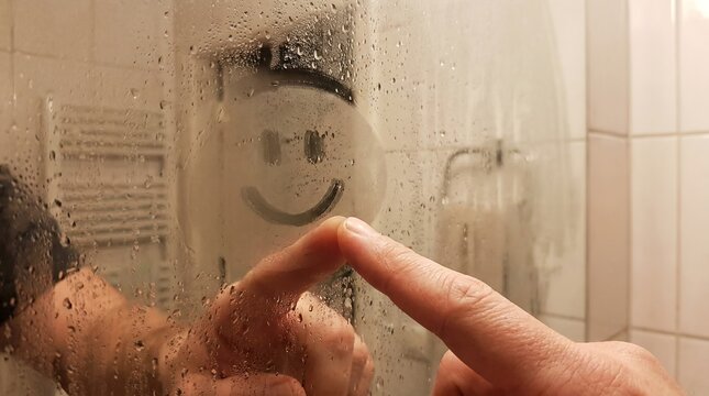 smiley face foggy mirror hand optimism bathroom steam playful care morning mood scene about mental wellness encouragement lighthearted comfort and positive lifestyle messaging for healthcare