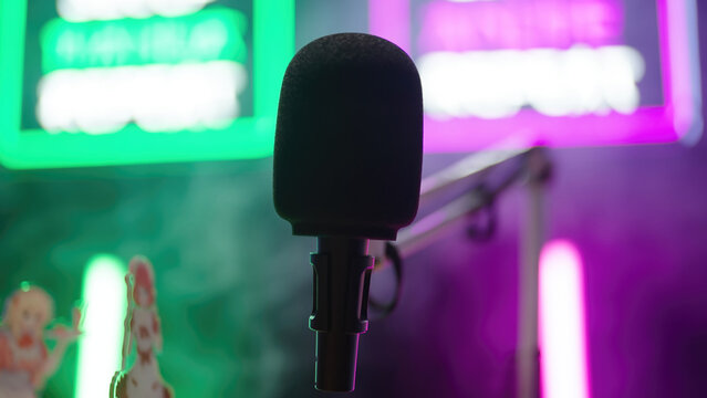 Microphone arm on a podcast studio with neon signs in background