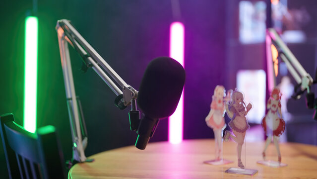 Microphone arm on a podcast studio with anime figurines on table