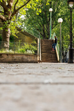 Une sc&egrave;ne urbaine &agrave; Paris montrant un homme utilisant un smartphone dans un escalier