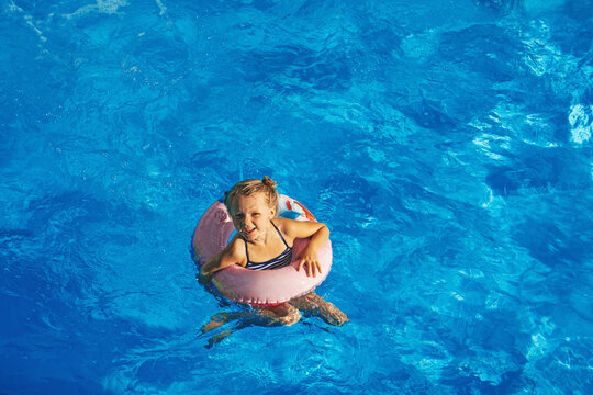 Child in swimming pool. Having fun on vacation at the hotel pool. Colorful vacation concept.