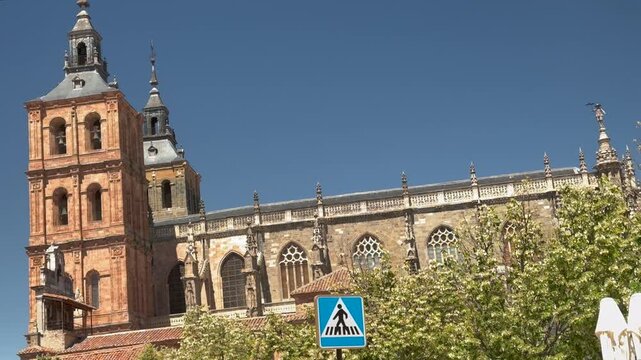 Vista arquitect&oacute;nica de la Catedral de Astorga en Le&oacute;n, Espa&ntilde;a. Catedral g&oacute;tica con hist&oacute;ricas torres campanario, fachada de piedra y detalles de arquitectura religiosa bajo un cielo azul despejado.