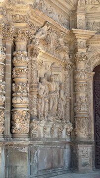 Vertical close-up of intricate stone carvings and religious sculptures on the facade of Astorga Cathedral in Le&oacute;n, Spain. Historic craftsmanship and decorative ecclesiastical architecture.