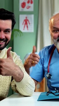 Indian male doctor with young male patient smiling showing ok sign after successful treatment as experienced physician gives thumbs up inside modern Indian clinic OPD healthcare visit