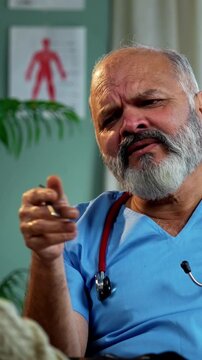 Indian male doctor consulting male patient during routine medical discussion as experienced physician advises young man inside modern Indian clinic OPD healthcare consultation