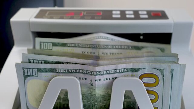 Electronic Money Counting Machine with Red Digital Display Processing a Stack of US 100 Dollar Bills