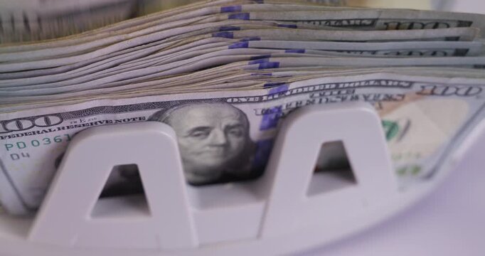 Electronic Money Counting Machine Processing a Stack of US 100 Dollar Bills with Benjamin Franklin Portrait, jib shot, slow motion