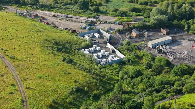 Aerial View Approaching BESS Battery Energy Storage System with Lithium-ion Containers near Substation. Grid management, AI energy optimization, and sustainable infrastructure. UK. 4K.