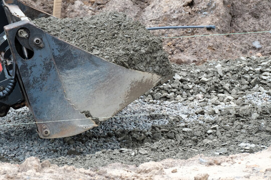 Heavy machinery moves wet concrete at a construction site