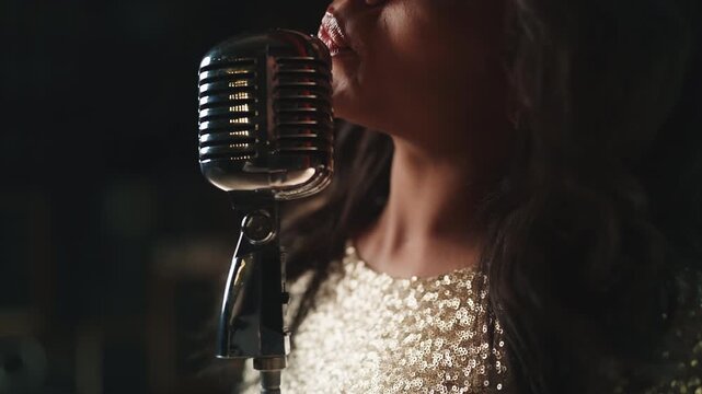 Close-up of an African American woman singing into a microphone  on stage