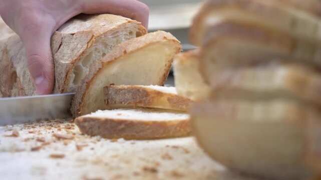 Restaurant worker prepares sliced bread for bruschetta appetizers while organizing food service for a large banquet and celebration.