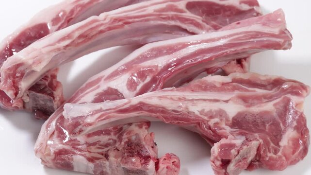 C&ocirc;tes d&rsquo;agneau isol&eacute;es sur une planche &agrave; d&eacute;couper