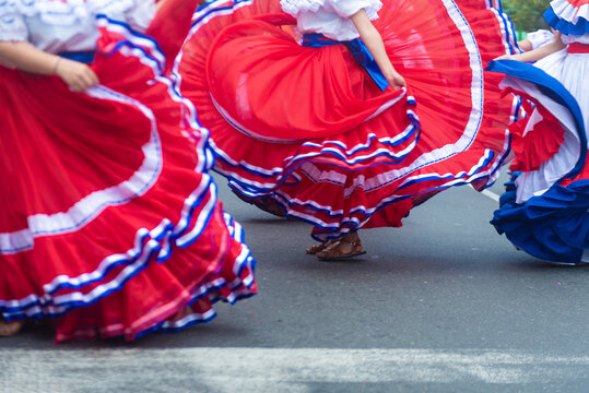 Women performing a folk dance in vibrant traditional clothing during a festive event.
