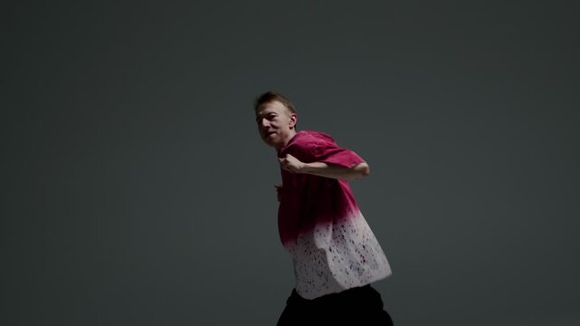 Hip hop dancer striking an energetic pose in a dark studio