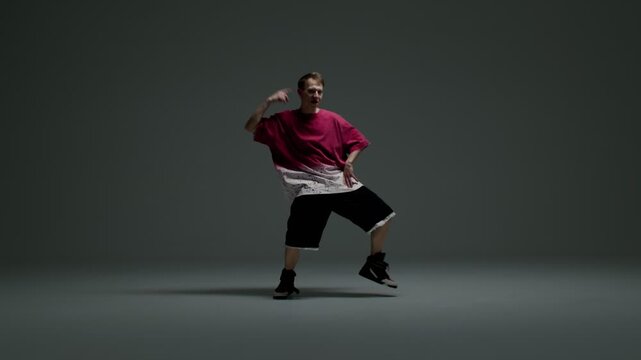 Hip hop dancer lifts knee in studio