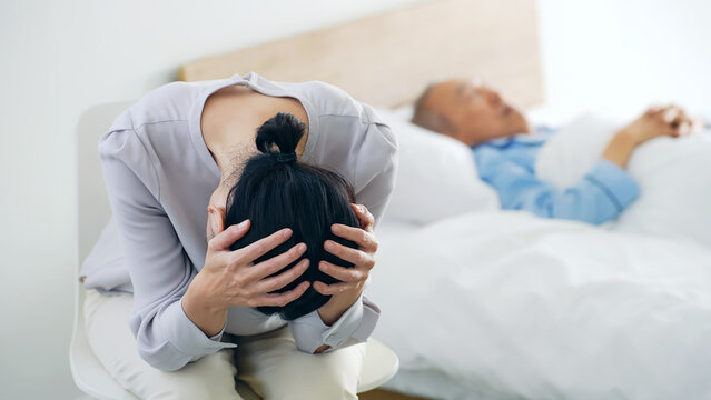 昏睡するシニア男性と悩む女性