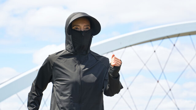 UVカットパーカーを着てウォーキングする女性