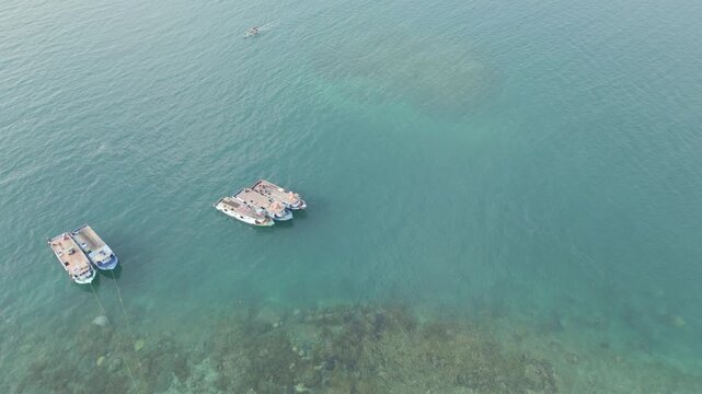 Top Down Aerial Of Boats Anchored Over Vivid Coral Reef Lampung
