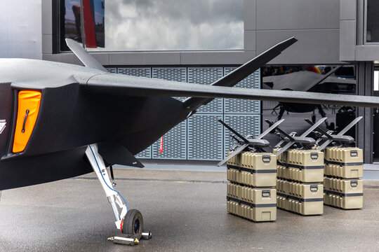Front view advanced unmanned aircraft uav missile carrier outdoors wet pavement cloudy sky. Futuristic aerospace technology surveillance defense innovation engineering autonomous aviation