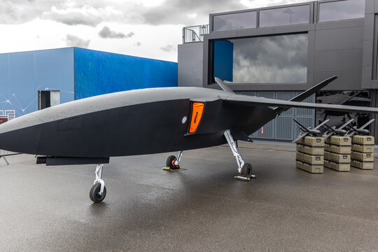 Front view advanced unmanned aircraft uav missile carrier outdoors wet pavement cloudy sky. Futuristic aerospace technology surveillance defense innovation engineering autonomous aviation