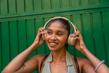 Fototapeta premium Happy young woman enjoying music with headphones outdoor
