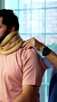 Indian physiotherapist treating young patient for neck and shoulder pain during physical therapy session as experienced male therapist provides manual treatment inside modern Indian clinic