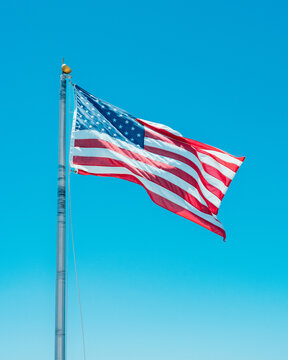 American Flag Waving Against Clear Blue Sky