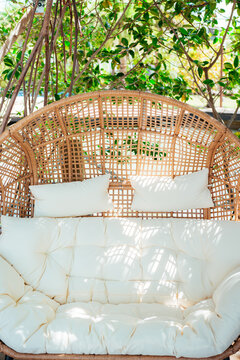 Wicker Outdoor Sofa with White Cushions in Tropical Garden