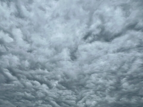 Full frame overcast sky filled with dense layered grey clouds on a cloudy day