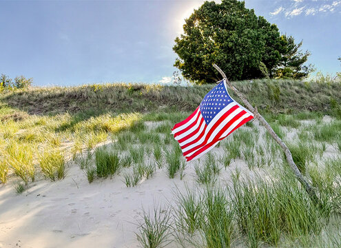 American Flag on Driftwood Stick in White Sand Dunes at Lake Michigan