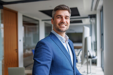Fototapeta premium Confident businessman smiling, standing in modern office, portraying success and professional leadership
