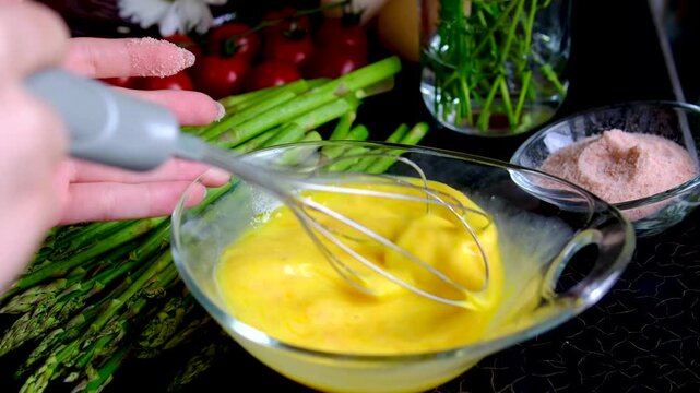 Healthy homemade breakfast with scrambled eggs and asparagus step by step cooking recipe on modern kitchen countertop with fresh summer atmosphere