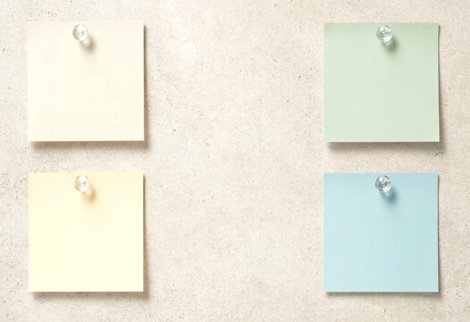 Four Square Sticky Notes Pinned to Textured Board