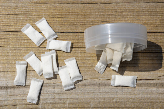 nicotine pouches tobacco free snus white sachets scattered from plastic container on wooden surface closeup with copy space for banner design concept of nicotine industry consumer products marketing