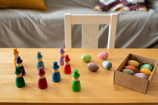 Colorful wooden toys and Easter eggs on table