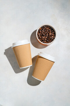 Roasted Coffee Beans and Takeaway Coffee Cups with on Light Background