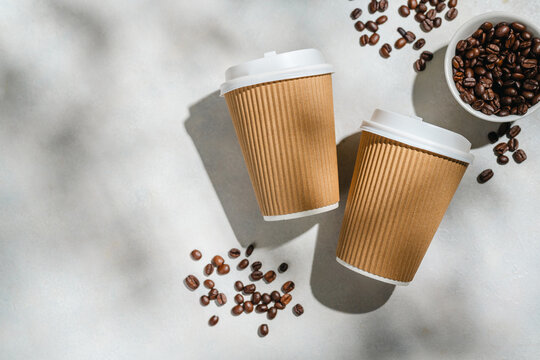 Roasted Coffee Beans and Takeaway Coffee Cups with on Light Background and soft shadows