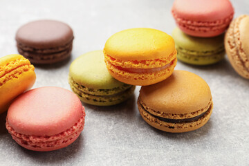 Fototapeta premium Yummy colorful macarons on light grey table, closeup