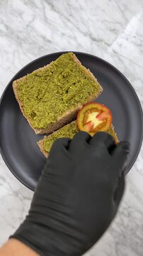 Spreading delicious, herbaceous pesto on bread adds an instant, fresh Mediterranean flair. It transforms a simple slice of bread into a savory, aromatic snack or appetizer.