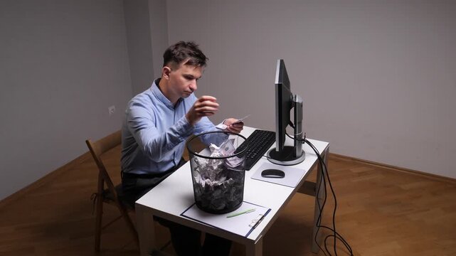 Businessman at office desk tossing banknotes into a waste bin, depicting financial loss, bad investments and wasted funds amid economic stress and professional frustration