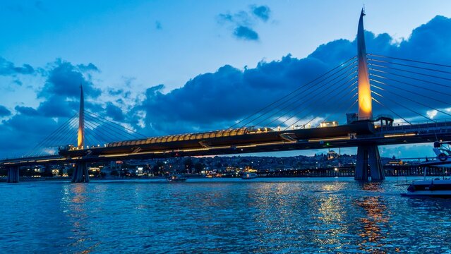 Istanbul, Turkey - June 12, 2026: Evening view of the Hali&ccedil; Bridge in Istanbul, Turkey, showing the bridge over the Golden Horn, city lights, waterfront buildings, calm water, and urban skyline