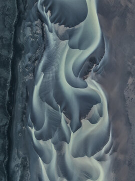 Aerial view of intricate glacial river patterns and volcanic sand formations at Solheimasandur, Vik, Myrdalshreppur, Iceland.