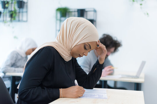 Stressed Muslim Student Struggling with Exam in College Classroom