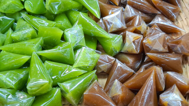 Traditional Thai sweet caramel candy known as Kalamae wrapped in small triangle plastic packaging arranged on wicker tray